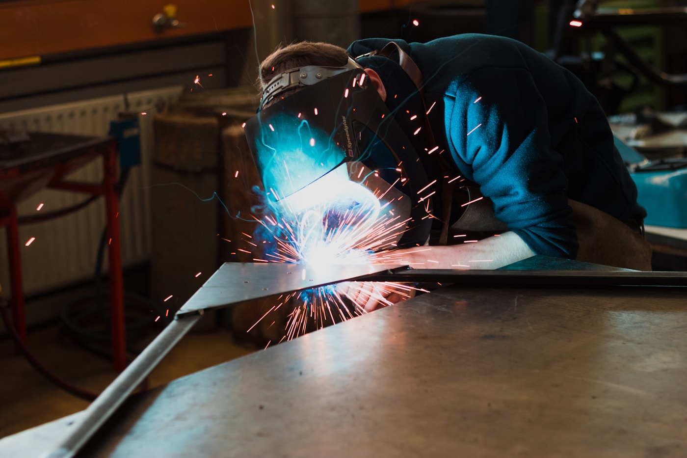 Welder working on a metal part in a workshop